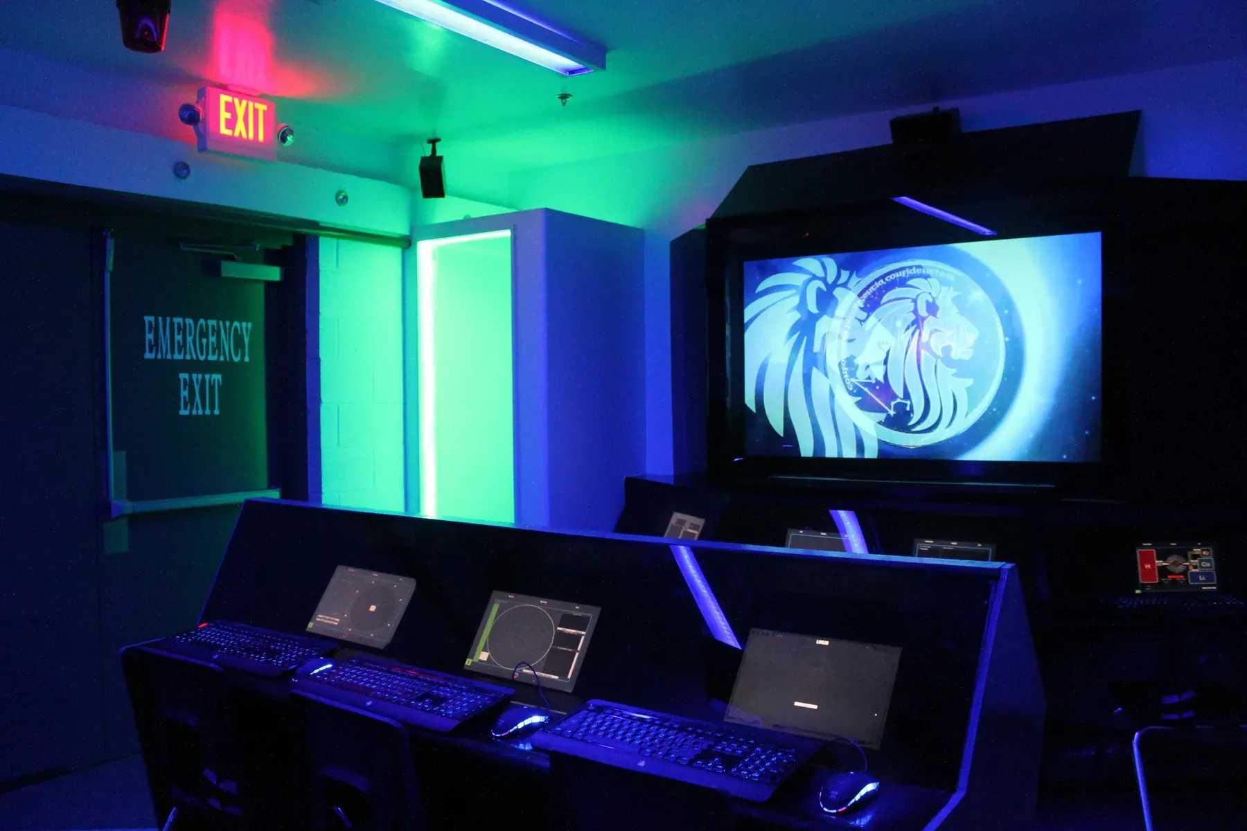 A school equipment closet converted into a glowing spaceship bridge, consoles in front of a big screen.
