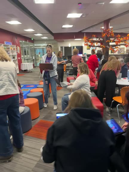 A library full of teachers working a Mission on their laptops.